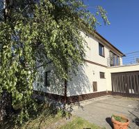 A family house in Zlaté Moravce with a garage and a terrace, surrounded by greenery and trees.