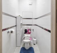 A bathroom in a 3-room apartment with white walls and a white toilet.