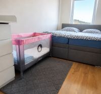 Bedroom with a baby crib in a 3-room apartment, floor with wooden decor.