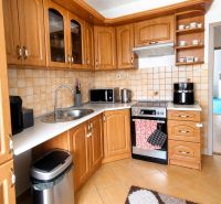 A kitchen in a 3-room apartment with wooden decor and appliances.