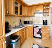 A kitchen in a 3-room apartment with wooden cabinets and a floor with a wooden decor.