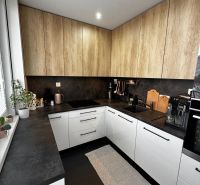 A kitchen with white cabinets and wooden decor in a 3-room apartment.