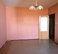 A room with pink walls and a brown floor in a 3-room apartment.