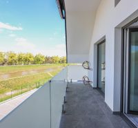 A balcony with a view of the river from a 4-room apartment, glass railing.