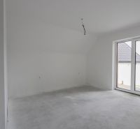 A spacious room with a gray floor and large windows in a 4-room apartment.