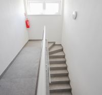 A staircase with a simple railing and windows in a 4-room apartment.