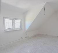 Attic room in a 4-room apartment with white walls and a skylight.