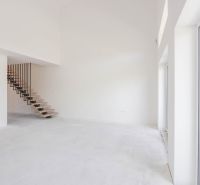 A spacious living room with a staircase and large windows in a 4-room apartment.