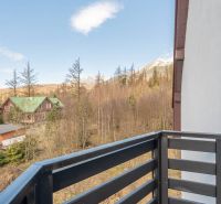 The balcony of a 4-room apartment in Vyšné Hágy with a view of the forest and mountains.