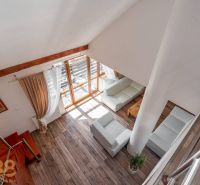 Living room with wood-patterned flooring, staircase, and large windows in a 4-room apartment.