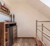 Interior of a 4-room apartment with a wooden decor floor, metal railing, and decorations.