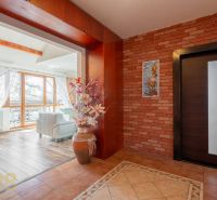 Interior of a 4-room apartment with a brick wall, wood-patterned flooring, and large windows.