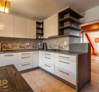 A kitchen in a 4-room apartment with a wooden decor floor and interesting lighting.