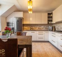 A modern kitchen with a dining table in a 4-room apartment with flowers on the table.