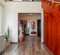 Interior of a 4-room apartment with a wooden decor floor and staircase.