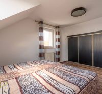 Bedroom in a 4-room apartment with a bed, a large wardrobe, and a floor with a wooden decor.