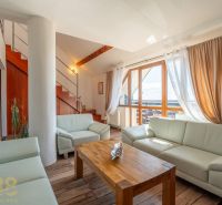 Living room with a light sofa, stairs, and a floor with a wood decor in a 4-room apartment.
