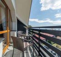 A balcony with rattan seating and floral decorations in a 4-room apartment in Vyšné Hágy.