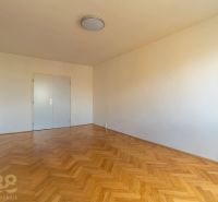 A room in a 4-room apartment with white walls and a wooden decor floor.