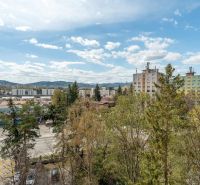 A view of apartment buildings surrounded by greenery and Partizánska Street in Poprad.