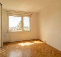 A bright room with large windows and a wooden decor floor in a 4-room apartment.