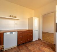 A kitchen in a 4-room apartment with a wood-patterned floor and built-in appliances.