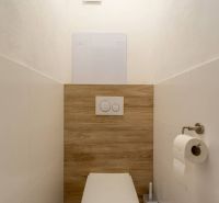 A minimalist toilet with a wall-hung WC and a floor with a wooden decor in a 4-room apartment.