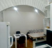 A kitchen in a 2-room apartment with an arched ceiling and a floor with a wooden decor.