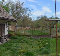 A family house in Horné Saliby with a lawn and a garden, surrounded by a fence.