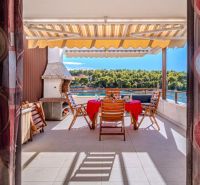 Brač holiday apartment with terrace, sea view, and outdoor chairs at the table.
