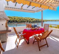 Terrace of a recreational apartment in Brač with a sea view and outdoor seating.
