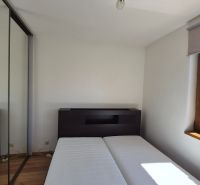 Bedroom in a holiday apartment with a wooden decor floor and a wardrobe.