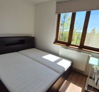 Bedroom with a double bed, wooden decor flooring, and a window in the Holiday Apartment.
