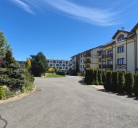 The greenery around the recreational apartments in Stará Lesná in the High Tatras under the blue sky.