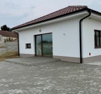 A family house on Hlavná Street in Vlčany with a white facade and a paved courtyard.