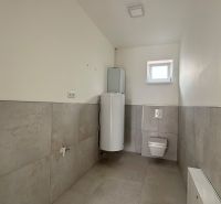 Bathroom in a family house with a toilet and a water heater.