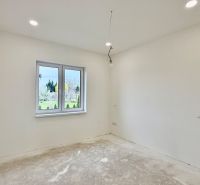 Empty room in a family house with white walls and a window overlooking the outside.