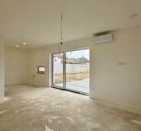 Interior of a family house with sliding doors, air conditioning, and space for a kitchen unit.