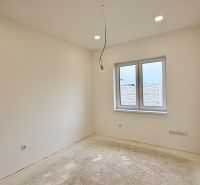 Bright room with a window and bare floor in a family house.