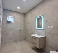 Bathroom in a family house with a modern sink, mirror, and ladder radiator.
