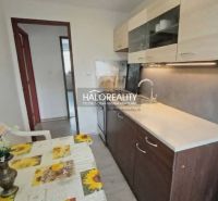 A kitchen in a 3-room apartment with a dining table, kitchen unit, and a wall in wooden decor.