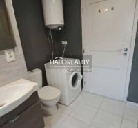 A bathroom in a 3-room apartment with a washing machine and a boiler, light-colored tiles.