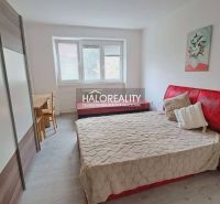 A bedroom with a red headboard and a wooden decor floor in a 3-room apartment.