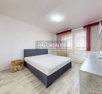 A bedroom with a bed, television, and a wooden decor floor in a two-room apartment.
