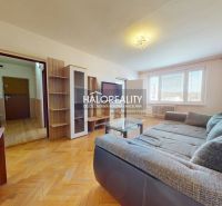 Living room with wood-patterned flooring, a sofa, and furniture in a two-room apartment.