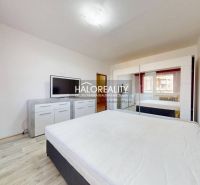 Bedroom with a white interior and a wooden decor floor in a 2-room apartment.