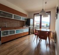 A kitchen in a 3-room apartment with a wooden decor floor and a dining table.