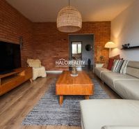 Living room in a 3-room apartment with a brick wall and a wooden decor floor.