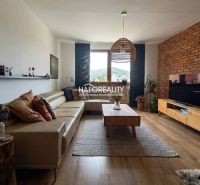 Living room with a leather sofa, TV, and wooden decor flooring in a 3-room apartment.