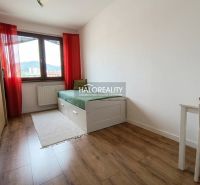A bright room with a bed, a table, and a floor with a wooden decor in a 3-room apartment.